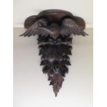 A carved wood Eagle fruit and berry clock bracket, 61cm tall x 56cm x 23cm deep, in generally good