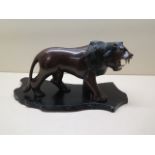 A carved hardwood lion on stand, 15cm tall x 29cm long, in good condition