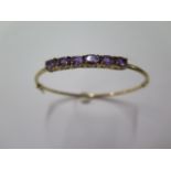 A 9ct yellow gold hinged amethyst bangle, 7.5cm x 6.5cm, approx 7.3 grams, in good condition