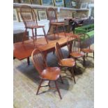 A modern cherrywood draw leaf table on turned legs with 6 ash and elm stick back chairs with