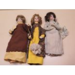 Three dressed porcelain headed dolls, tallest 28cm, one with a broken neck