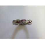 A platinum ruby and diamond ring of plaited design with one strand of channel set calibre cut rubies