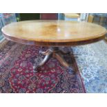 A Victorian Walnut tilt top oval loo table on a quatrefoil base , 67 cm tall 152 x 110 cm