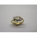 A hallmarked 18ct yellow gold three stone ring, size L, the central emerald cut diamond approx 4mm x