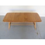 An Ercol light elm coffee table, model 459, with an undertier, 36cm tall x 104cm x 46cm, in good
