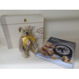 A boxed Steiff teddy bear with book 125 years of Steiff, dust sheet ripped to book, cinnamon bear