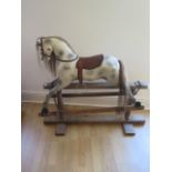 A vintage grey rocking horse with horse hair mane and tail and leather saddle, some losses and