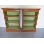 A pair of new walnut bookcases with adjustable shelves and painted interior, made by a local