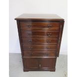 An Edwardian mahogany Wellington chest cabinet with 5 drawer above 2 cupboard doors with key,