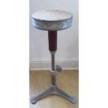 An industrial aluminum revolving stool adjustable in height on a triform base