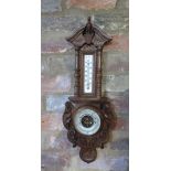 A carved oak barometer with thermometer, 57cm tall