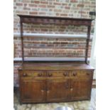 A Georgian oak country dresser with an open rack top above 3 freize drawers and 3 cupboard doors,