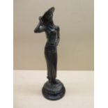 A bronze figure of a 1920s girl on a black slate base
