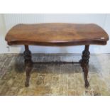 A Victorian burr walnut stretcher table with a shaped top on carved supports united by a