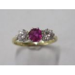 An 18ct gold and platinum three stone diamond and ruby / spinnel ring, diamonds approx 0.20ct