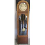 An 8 day oak case clock with Westminster chimes and exposed pendulum, running order,chimes may need