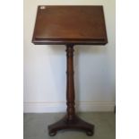 A Victorian mahogany folding top music / reading stand on a turned column and tripartite base,