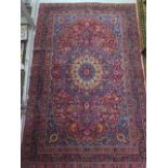 A vintage woollen rug with a red field and a central medallion, 197cm x 129cm, wear mainly to