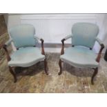 A a pair of carved open armchairs with scroll arms on shaped carved front legs with horsehair