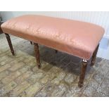 An upholstered window stool on six turned reeded legs, 54cm tall x 116cm x 49cm, in good condition