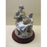 A Lladro group flower seller and gentleman at a cafe on wooden stand, 31cm tall, appears to be in