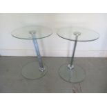 A pair of glass and chrome side tables 54cm tall x 43cm diameter