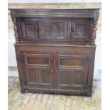 An 18th century carved oak court cupboard with two small doors above two large panelled doors with