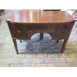 A mahogany bow fronted side cabinet with 3 drawers on square tapering legs, 76cm tall