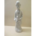 A Chinese 18th century Fukien porcelain figure of a Court lady and child holding a lotus, 36cm tall,