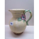 A Clarice Cliff relief decorated jug, 22cm tall, in good condition