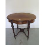 An Edwardian inlaid side table with a shaped top on carved reeded legs united by an undertier,