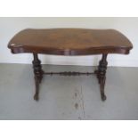 A good Victorian burr walnut stretcher table with a shaped top on twin carved supports united by a