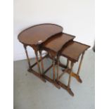 A nest of three walnut tables with shaped tops, 59cm tall x 55cm wide