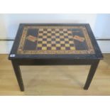 An ebonised chess games table with lift up top