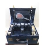 A Mappin and Webb blue leather fitted travel case with 8 silver top bottles, 4 silver back brushes