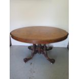 A good Victorian burr walnut tilt top oval breakfast table on a carved quatrefoil column base,