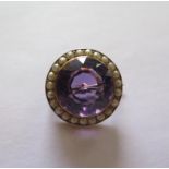 An early 20th century yellow metal amethyst and seed pearl brooch, round amethyst 15mm x 15mm x10.