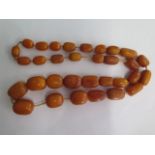 A string of butterscotch amber beads, largest bead approx 25mm x 20mm, total weight approx 115 grams