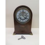 A mahogany inlaid striking mantle clock with exposed escapement and enamel dial and brass feet, 29cm