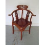 A 20th century Oriental hardwood carved corner comfort chair, 85cm tall x 69cm wide