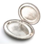 A pair of George III graduated silver meat platters, by William Frisbee, London 1801, oval form,