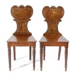 A PAIR OF REGENCY MAHOGANY HALL CHAIRS EARLY 19TH CENTURY each with a gorget shaped back, solid seat