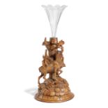 A BLACK FOREST LINDEN WOOD EPERGNE LATE 19TH CENTURY carved with a stag on a rocky mound with