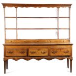 A GEORGE III WELSH OAK DRESSER LATE 18TH CENTURY the plate rack with a wavy frieze, two shelves