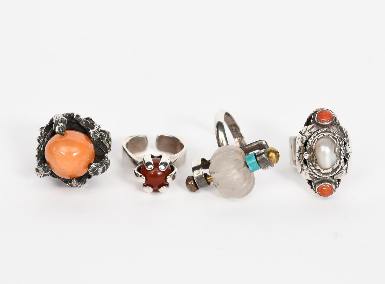 An English silver ring, the clasp ball shoulder encasing a spherical red/amber stone, a Mexican