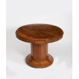 An Art Deco walnut veneer circular library table, on faceted drum base and flaring foot, the