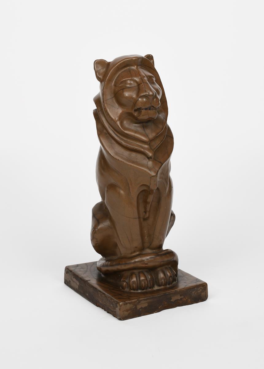 An architectural stoneware model of a seated lion, in the manner of Alfred Stevens, covered in a