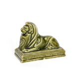 A Carter's Poole Pottery Lion paperweight, modelled as a lion, lying, holding a shield with an Art