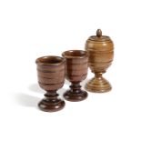 A PAIR OF TREEN WALNUT GOBLETS 19TH CENTURY with incised bands and on turned feet, together with a