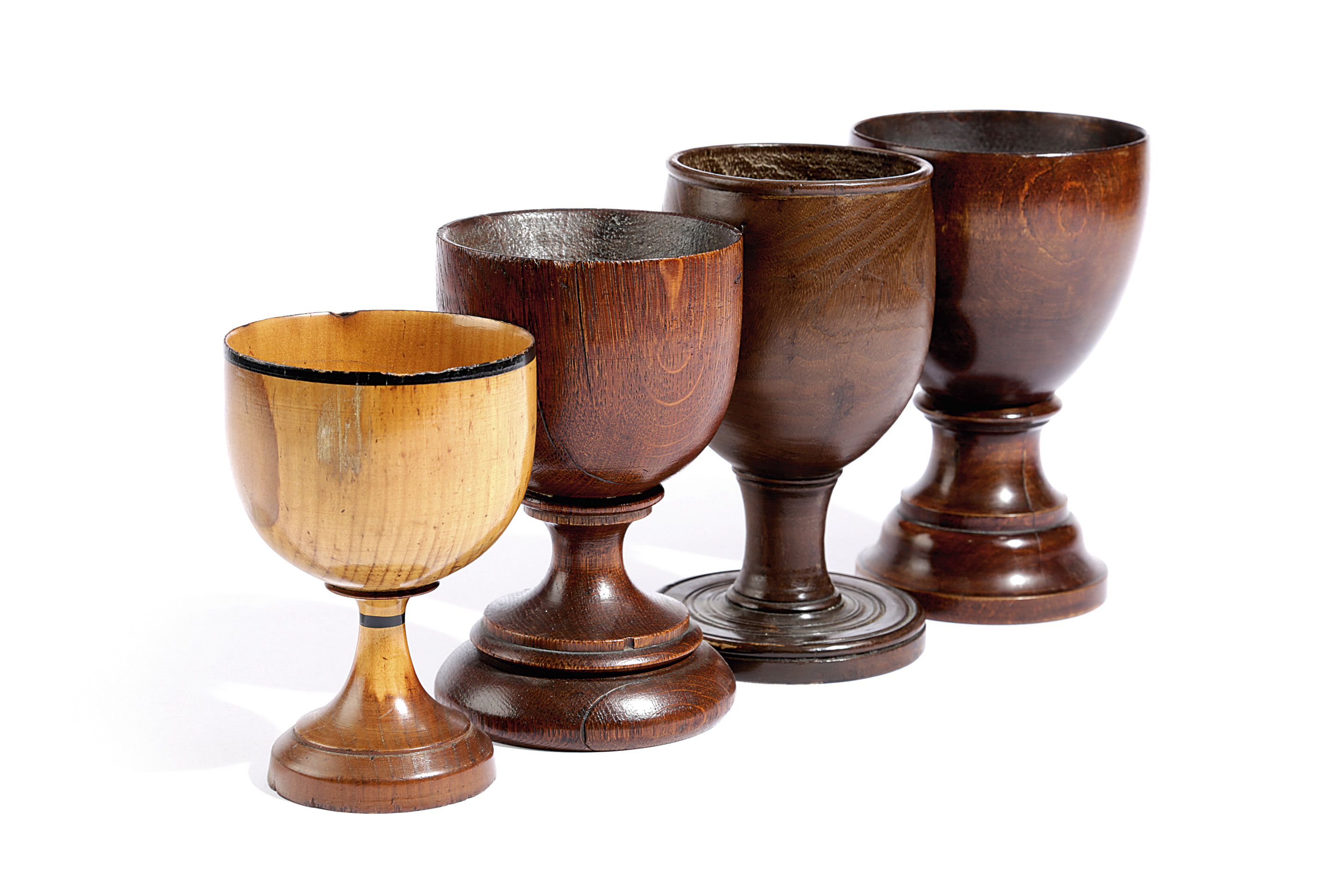 FOUR TREEN GOBLETS PROBABLY 19TH CENTURY including: one turned in oak, the underside of the foot